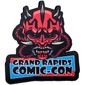 Embroidered patch for Grand Rapids Comic-Con featuring a red and black horned demon mask with tusks.