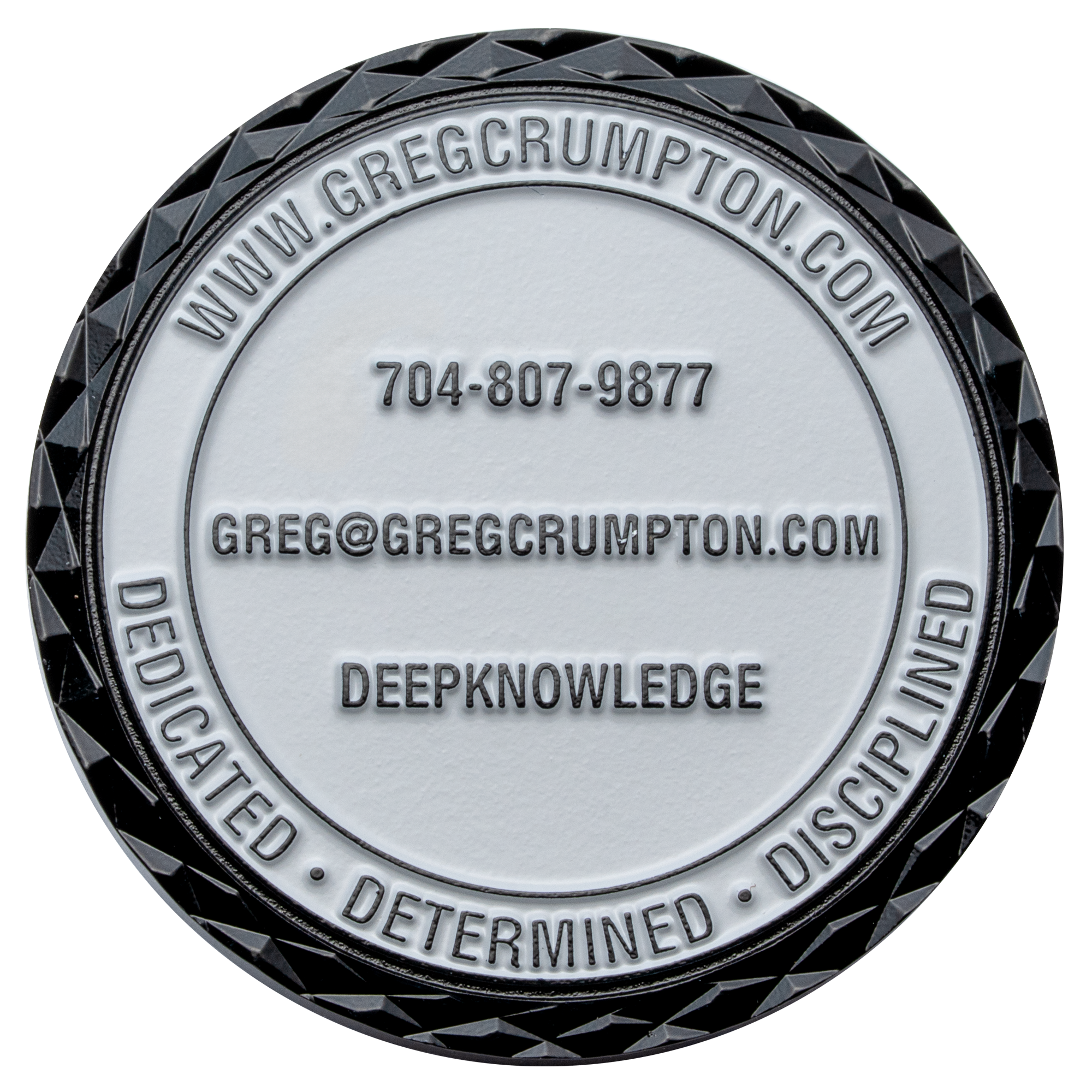 Round challenge coin with black diamond cut edge, white center, and Greg Crumpton contact information.