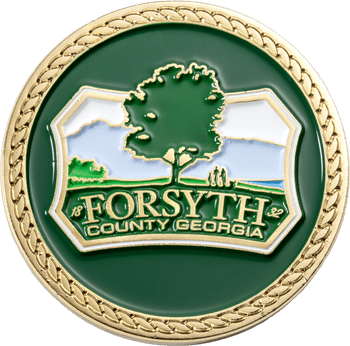 Gold and green challenge coin featuring the Forsyth County Georgia seal with a tree and mountain landscape.