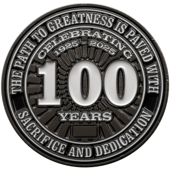 Black and silver challenge coin featuring a large white 100 and the text Celebrating 1925-2025 with sacrifice and dedication.
