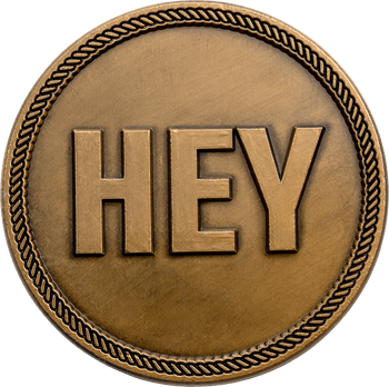 Round antique bronze challenge coin featuring the word HEY in raised bold letters inside a rope border.