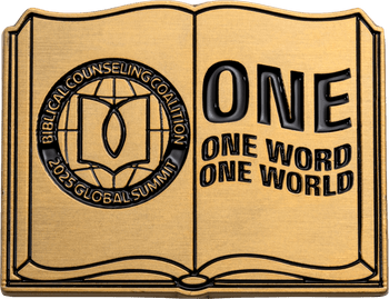 Book-shaped challenge coin for Biblical Counseling Coalition 2025 Global Summit with ONE Word ONE World text.