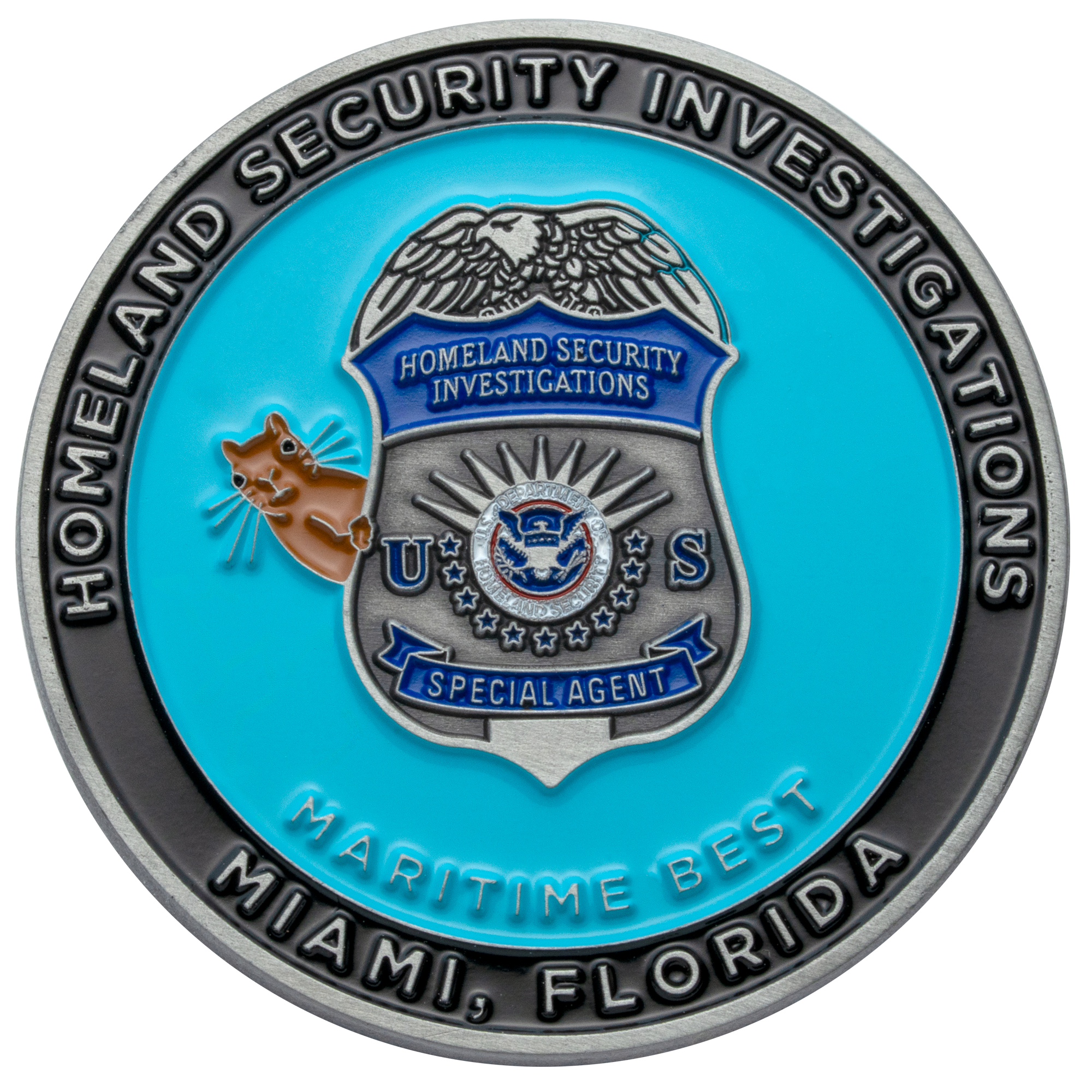 Challenge coin featuring the Homeland Security Investigations Special Agent badge, a manatee mascot, and blue enamel background.