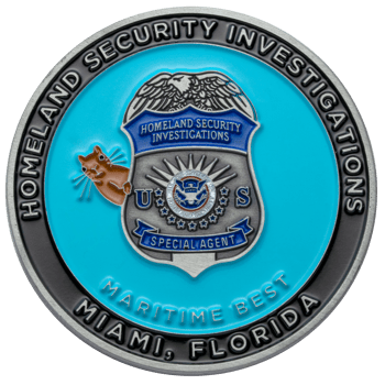 Challenge coin featuring the Homeland Security Investigations Special Agent badge, a manatee mascot, and blue enamel background.