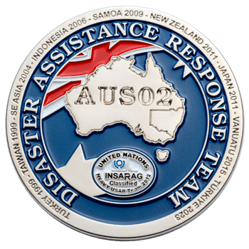 Disaster Assistance Response Team challenge coin featuring an Australian map, AUS02 text, and UN INSARAG logo with a list of deployment locations and dates.