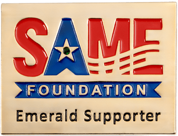 Rectangular gold lapel pin for SAME Foundation Emerald Supporter with red and blue enamel lettering and a green gemstone.