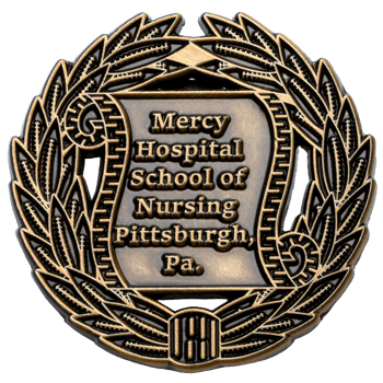 Antiqued gold lapel pin for Mercy Hospital School of Nursing Pittsburgh featuring a scroll and wreath design.