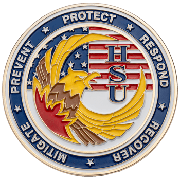 Circular enamel challenge coin with HSU text, an eagle head, and American flag motif, bordered by the words prevent, protect, respond, recover, and mitigate.
