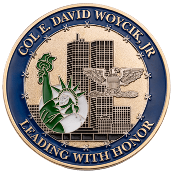 Custom gold challenge coin with blue border featuring Statue of Liberty, Twin Towers, and an American eagle with text Col. E. David Woycik, Jr.